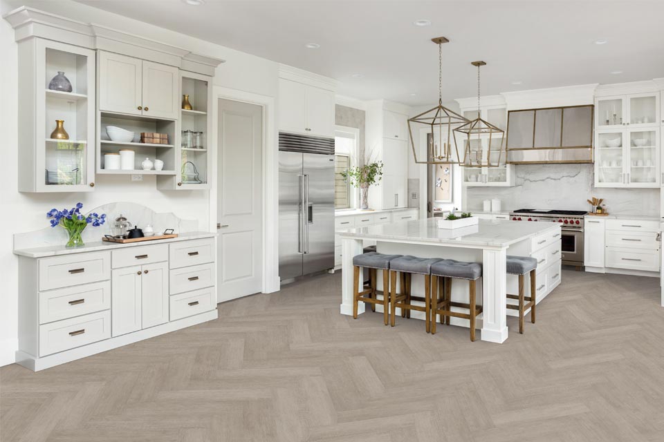 wood look flooring in kitchen with white cabinets and kitchen island with wood stools.